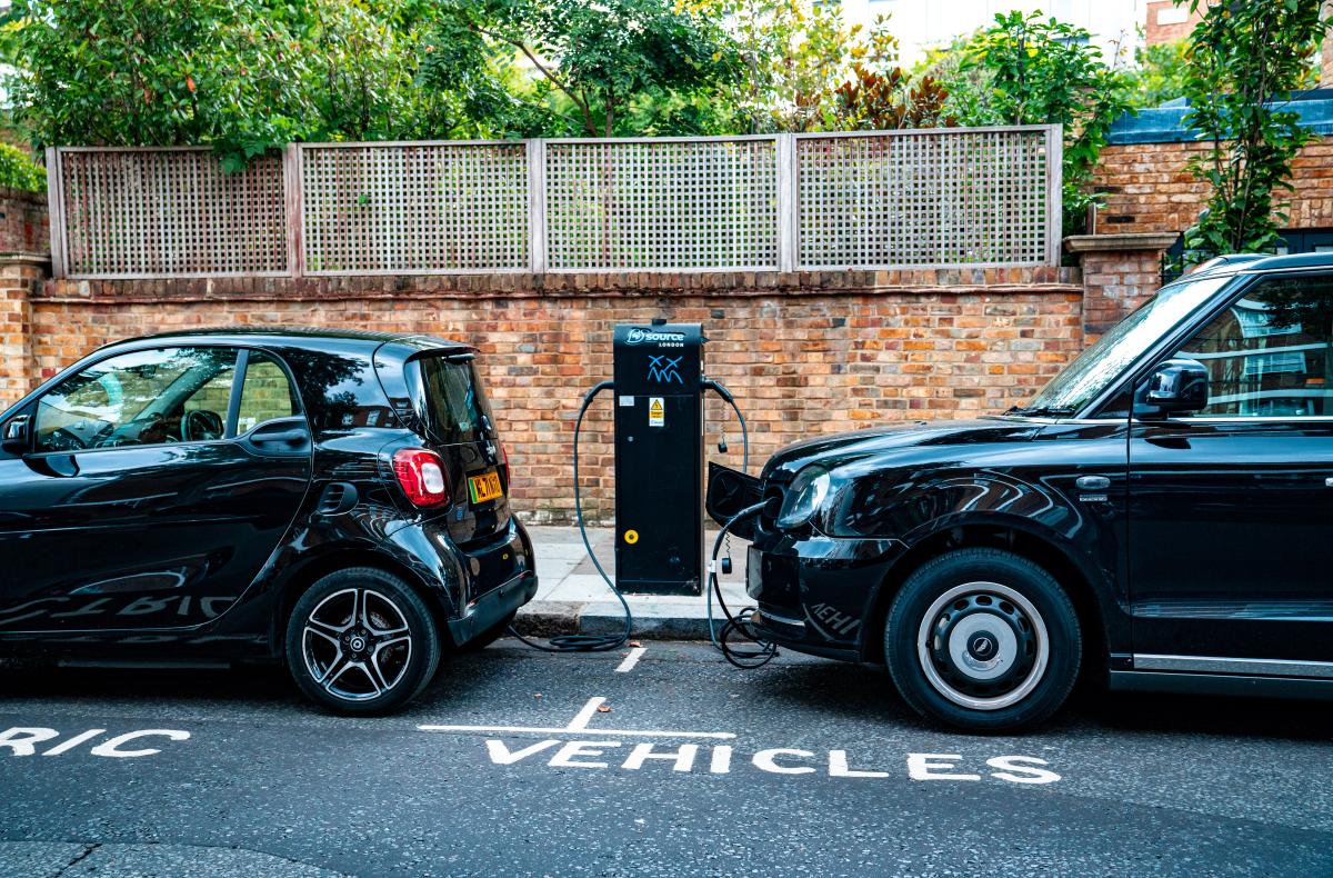 two cars parked on the site of the road, charging from an electric charging station