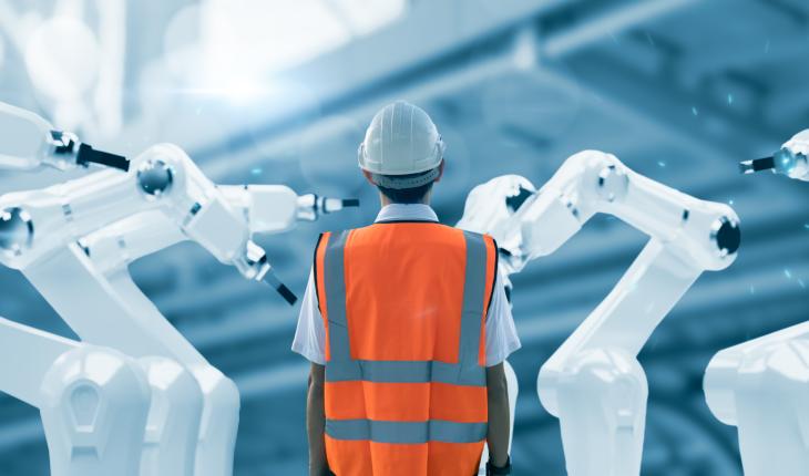Man in safety gear surrounded by robotic arms