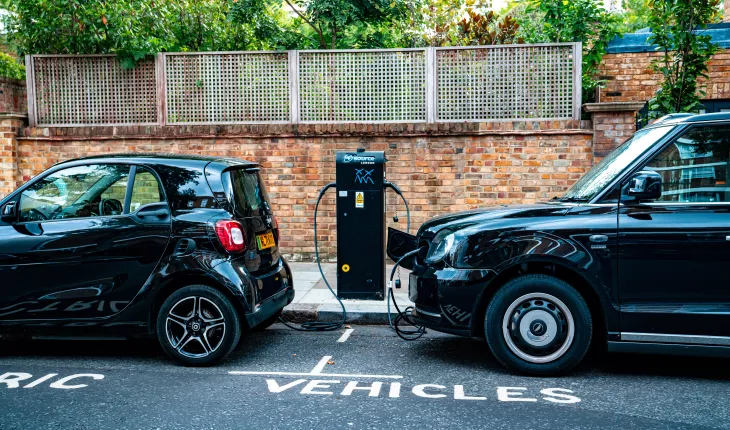 two cars parked on the site of the road, charging from an electric charging station