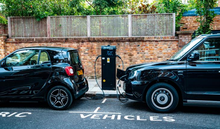 two cars parked on the site of the road, charging from an electric charging station